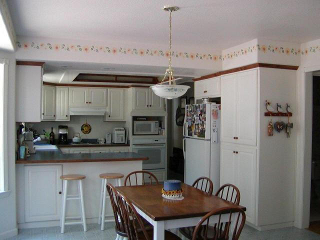 8277 Placer Road Redding, CA 96001 - Photo 8 of 9 a kitchen with stainless steel appliances granite countertop a dining table chairs and white cabinets