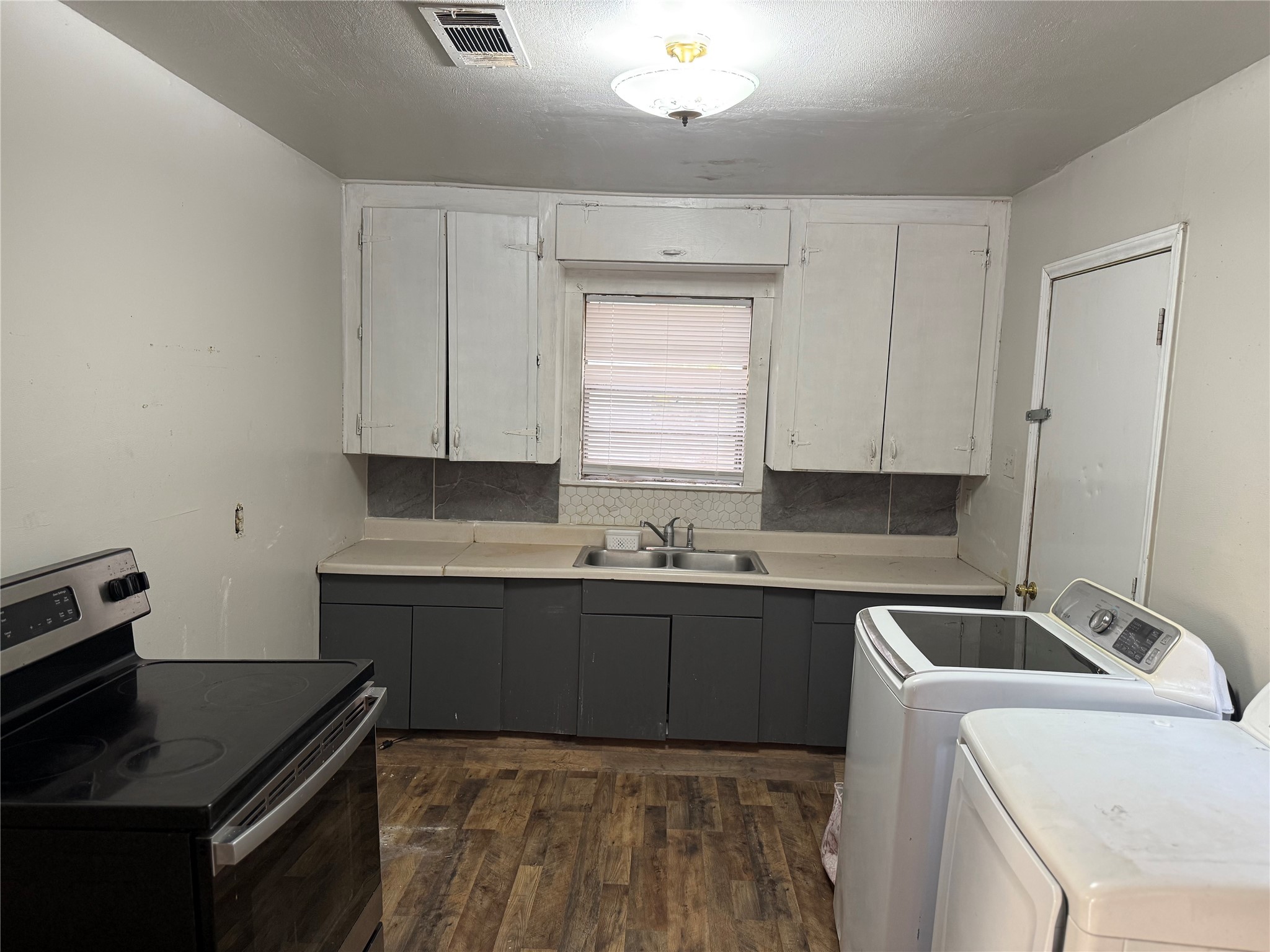 2210 Utica Street Beaumont, TX 77703 - Photo 12 of 17 a kitchen that has a sink and a stove in it