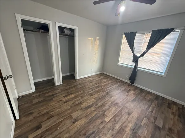 an empty room with wooden floor and a window