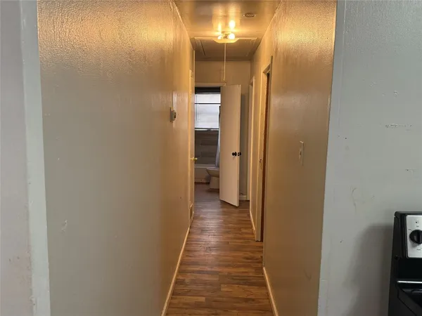 a view of a hallway with wooden floor