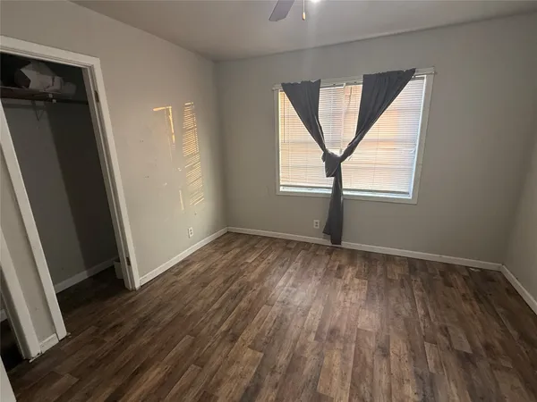 an empty room with wooden floor and a window