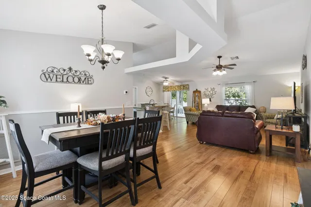 a view of a dining room with furniture wooden floor and chandelier