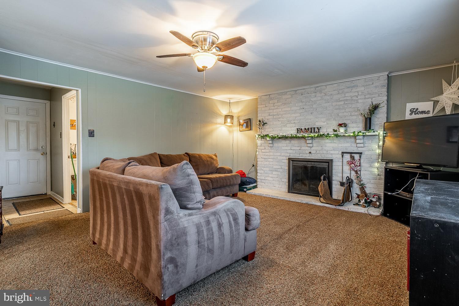 421 Hampton Lane Somerdale, NJ 08083 - Photo 12 of 35 a living room with furniture a fireplace and a flat screen tv