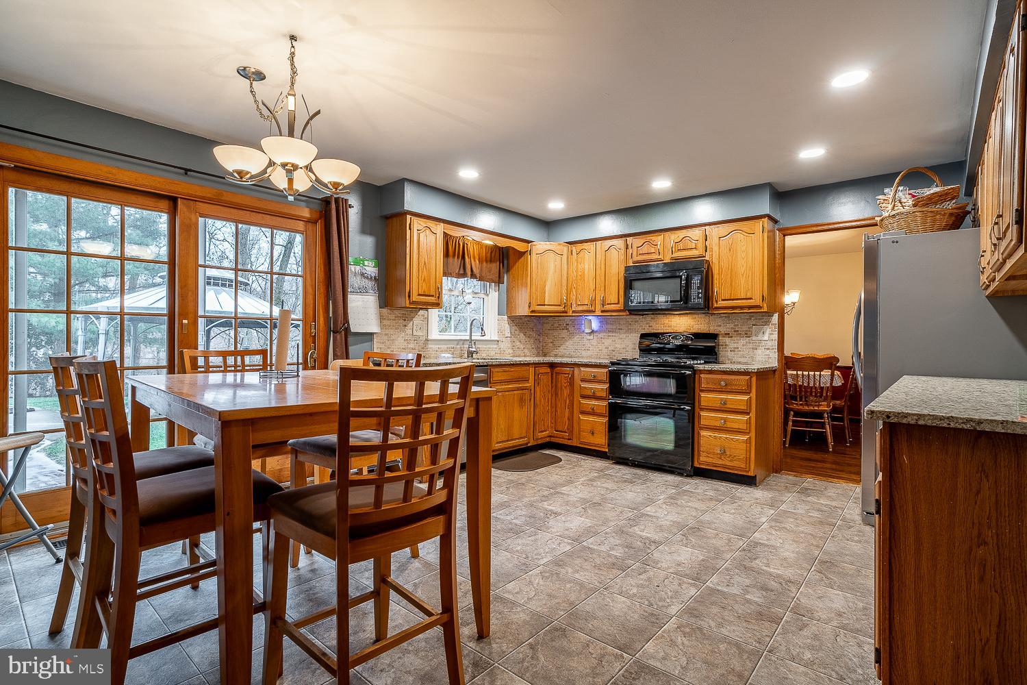 421 Hampton Lane Somerdale, NJ 08083 - Photo 9 of 35 a kitchen with stainless steel appliances granite countertop a stove top oven a sink dishwasher a dining table and chairs with wooden floor