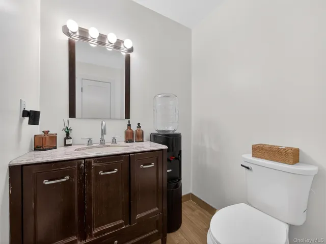a bathroom with a granite countertop toilet sink and mirror