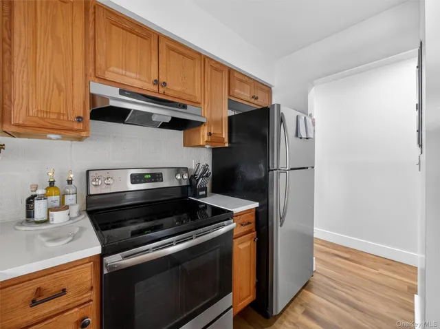 a kitchen with stainless steel appliances granite countertop a refrigerator stove and cabinets