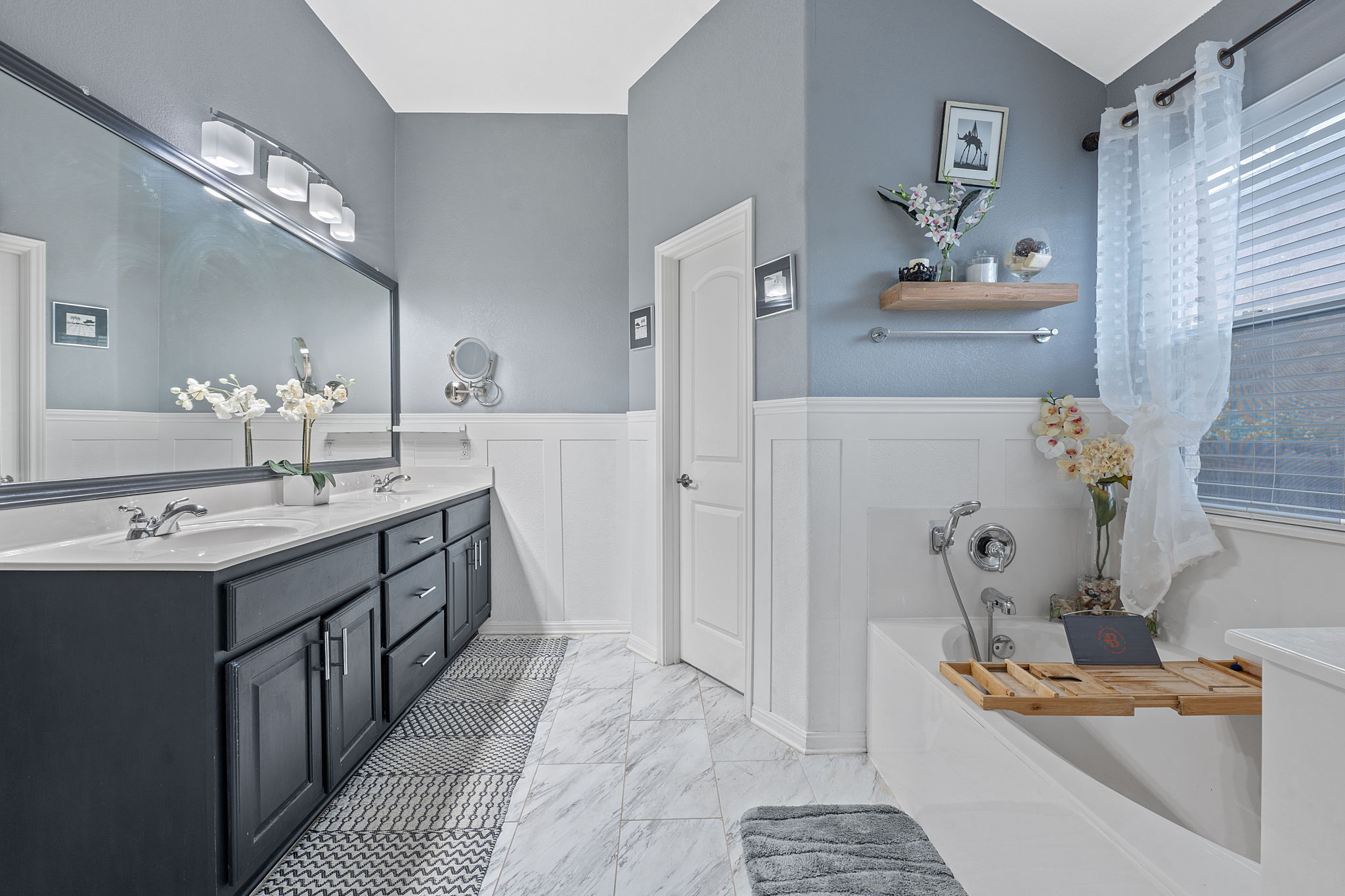 150 Manchester Lane Austin, TX 78737 - Photo 13 of 24 Bathroom featuring double vanity, wainscoting, a garden tub, a decorative wall,