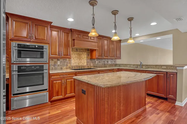 a kitchen with stainless steel appliances granite countertop a sink and cabinets