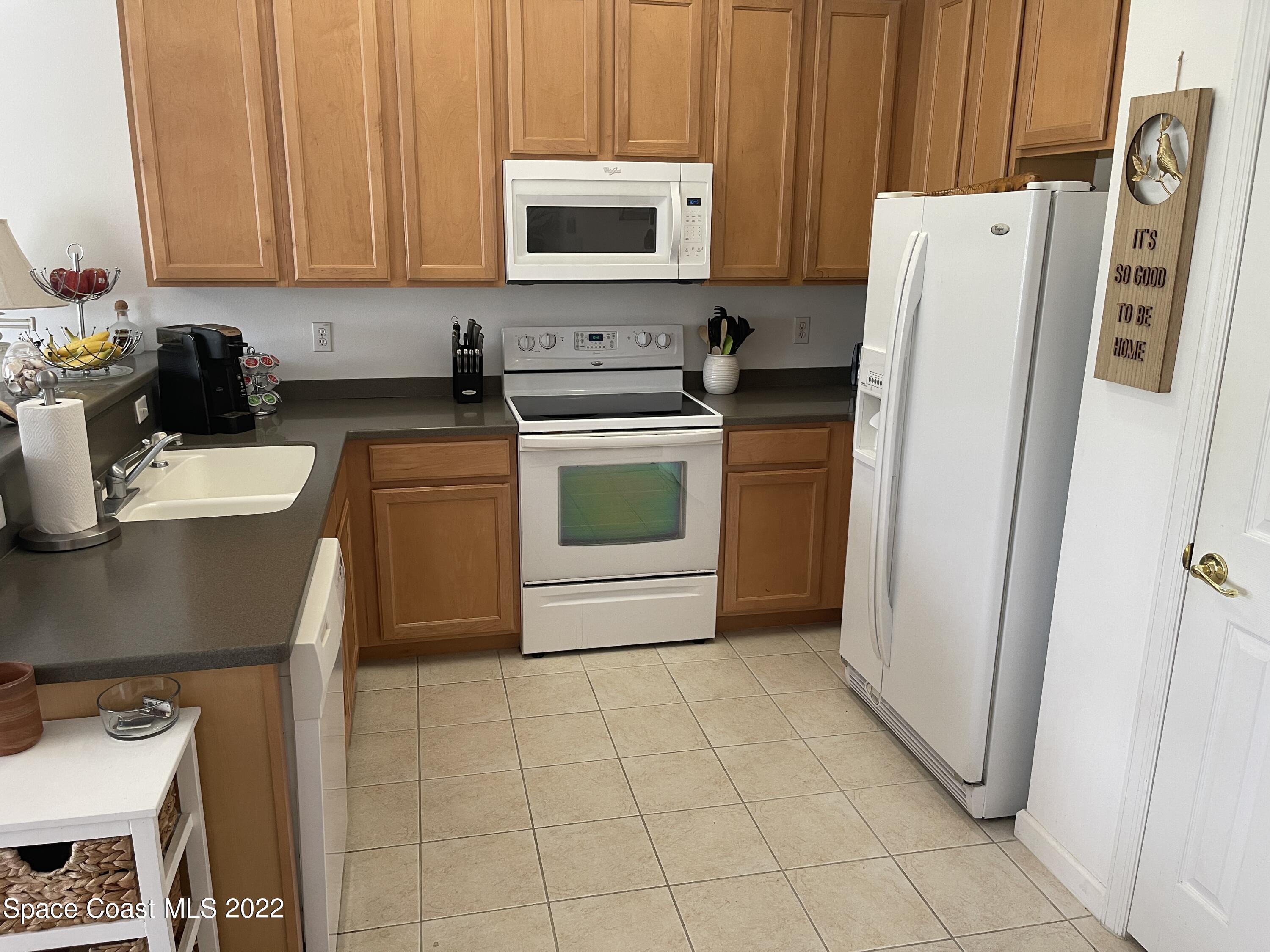 2795 Reston Street, Unit 105 Melbourne, FL 32935 - Photo 5 of 30 a kitchen with a refrigerator sink and cabinets