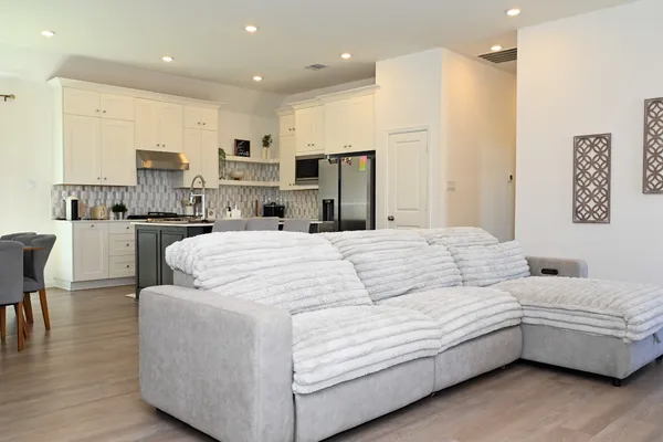 a living room with furniture kitchen view and a refrigerator