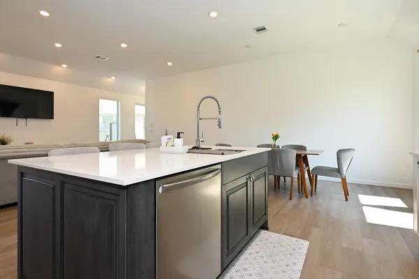 a kitchen with a kitchen island wooden cabinets and sink