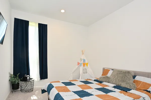 a bedroom with a bed and a potted plant