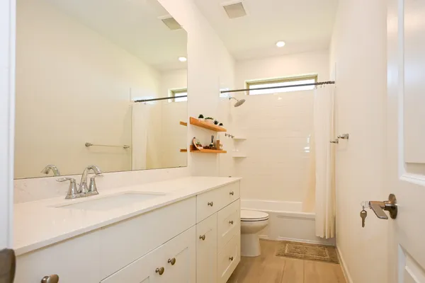 a bathroom with a sink a toilet and shower