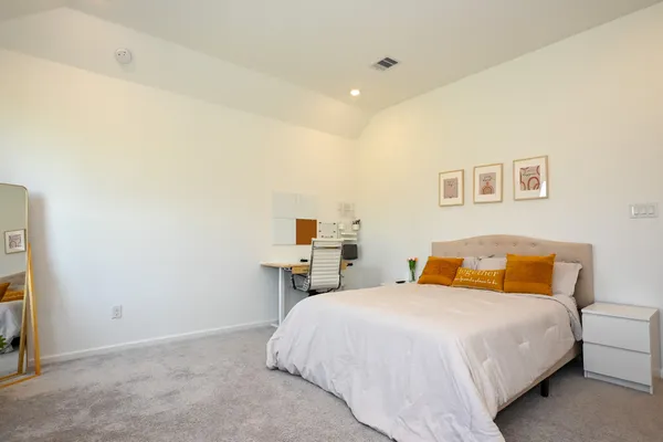 a bedroom with a bed and a painting on the wall