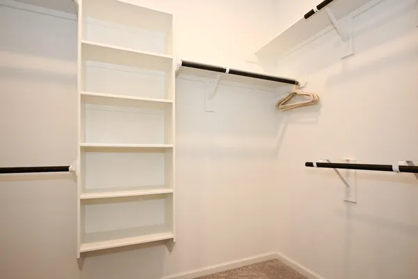 a view of walk in closet with empty racks