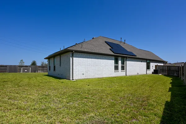 a house with green field in front of it