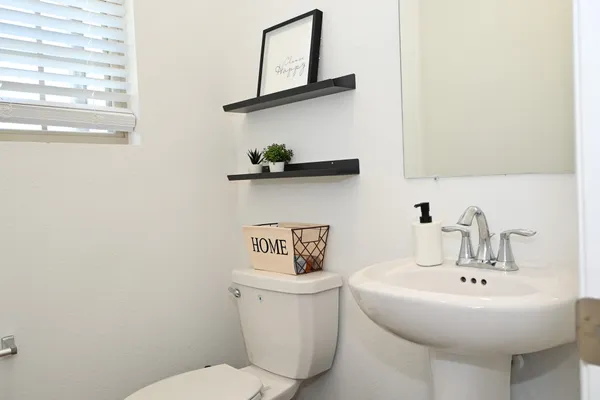 a bathroom with a toilet a sink and mirror