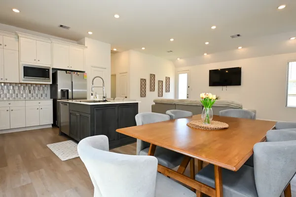 a living room with stainless steel appliances kitchen island granite countertop furniture a dining table and chairs
