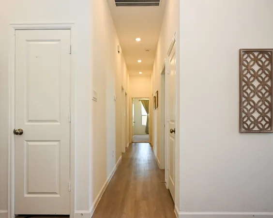 a view of a hallway with wooden floor