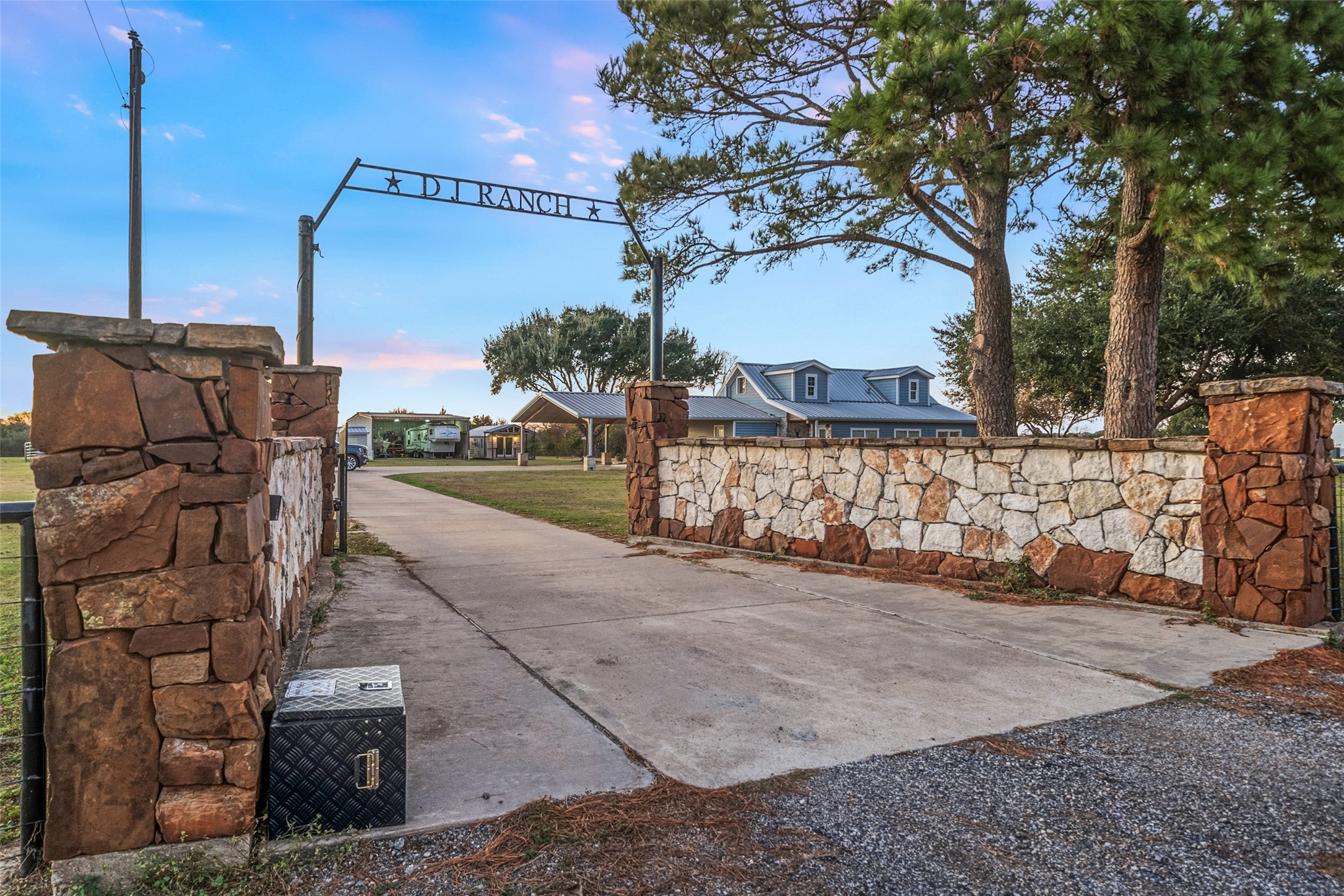 19989 Meadow Bend Road Hempstead, TX 77445 - Photo 10 of 35 Gated entry with stone columns opens to a long concrete drive leading to the home, barn, and additional improvements.