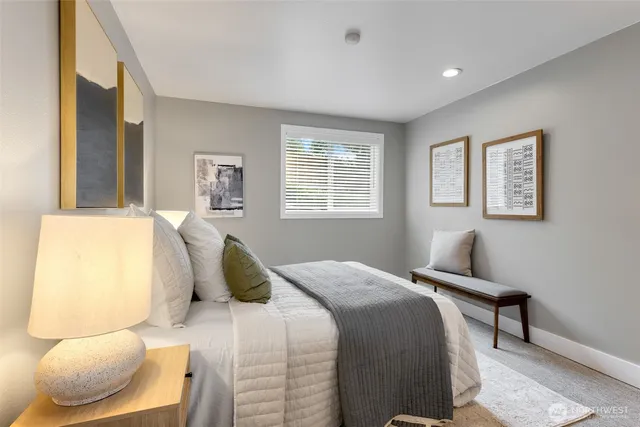 a bedroom with a bed and painting on the wall