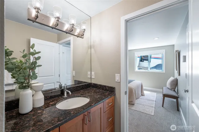 a bathroom with a granite countertop sink a toilet and a mirror
