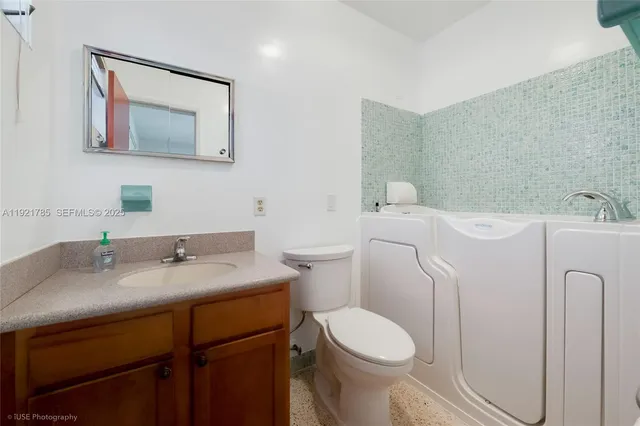 a bathroom with a granite countertop toilet sink and mirror