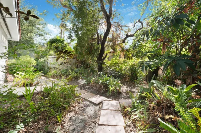 a backyard of a house with lots of green space and garden