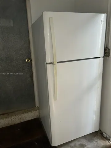 a white refrigerator freezer and a stove sitting inside of a refrigerator