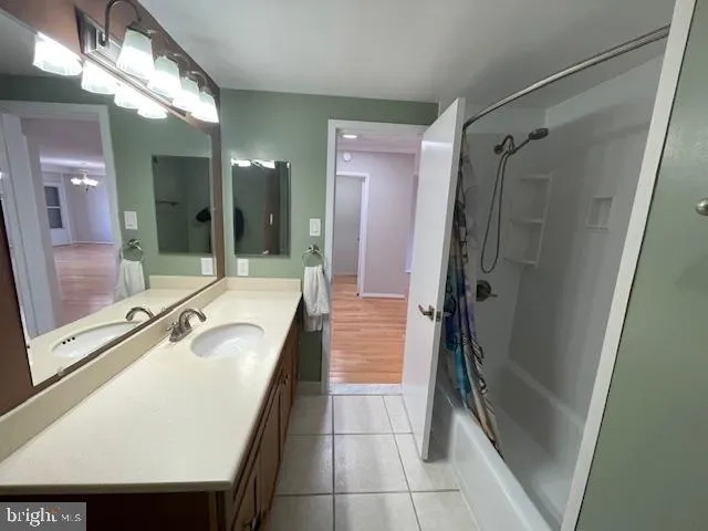 a bathroom with a tub a sink a mirror and a shower