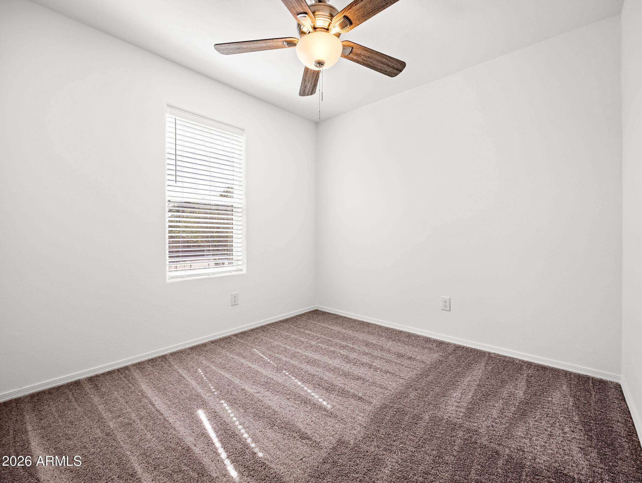 18296 Frontier Road Peeples Valley, AZ 86332 - Photo 20 of 44 an empty room with chandelier fan and windows