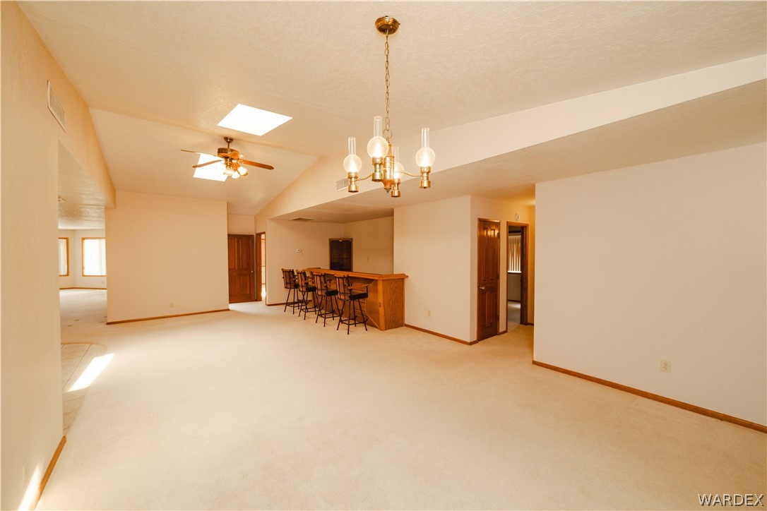 2100 East Valley View Road Kingman, AZ 86409 - Photo 8 of 53 Spacious interior featuring a built-in bar, vaulted ceilings, and a ceiling fan