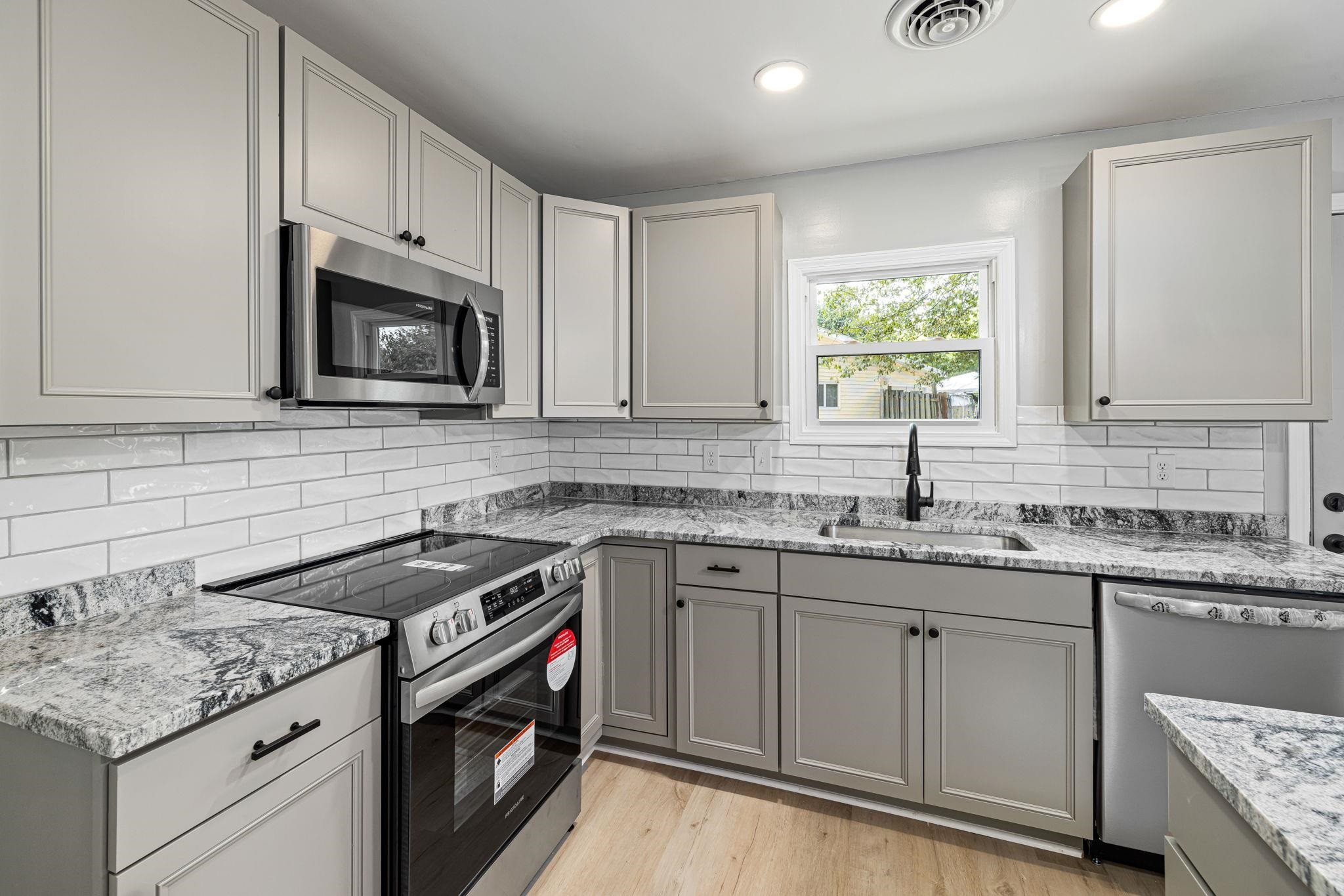 1200 Armstrong Circle Raleigh, NC 27610 - Photo 6 of 44 a kitchen with granite countertop a sink stove and cabinets