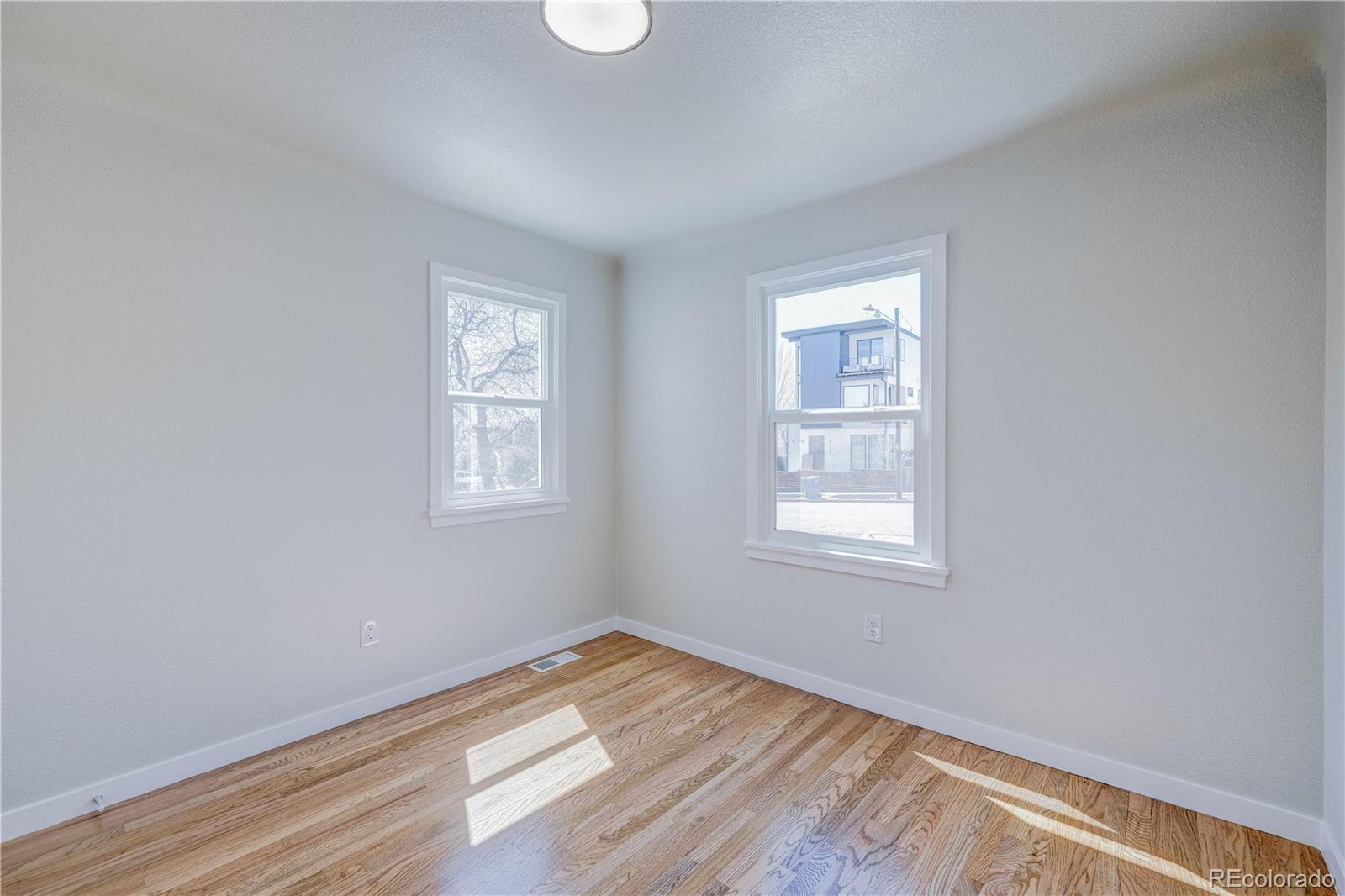 2932 Chase Street Wheat Ridge, CO 80214 - Photo 14 of 30 a view of an empty room with wooden floor and a window