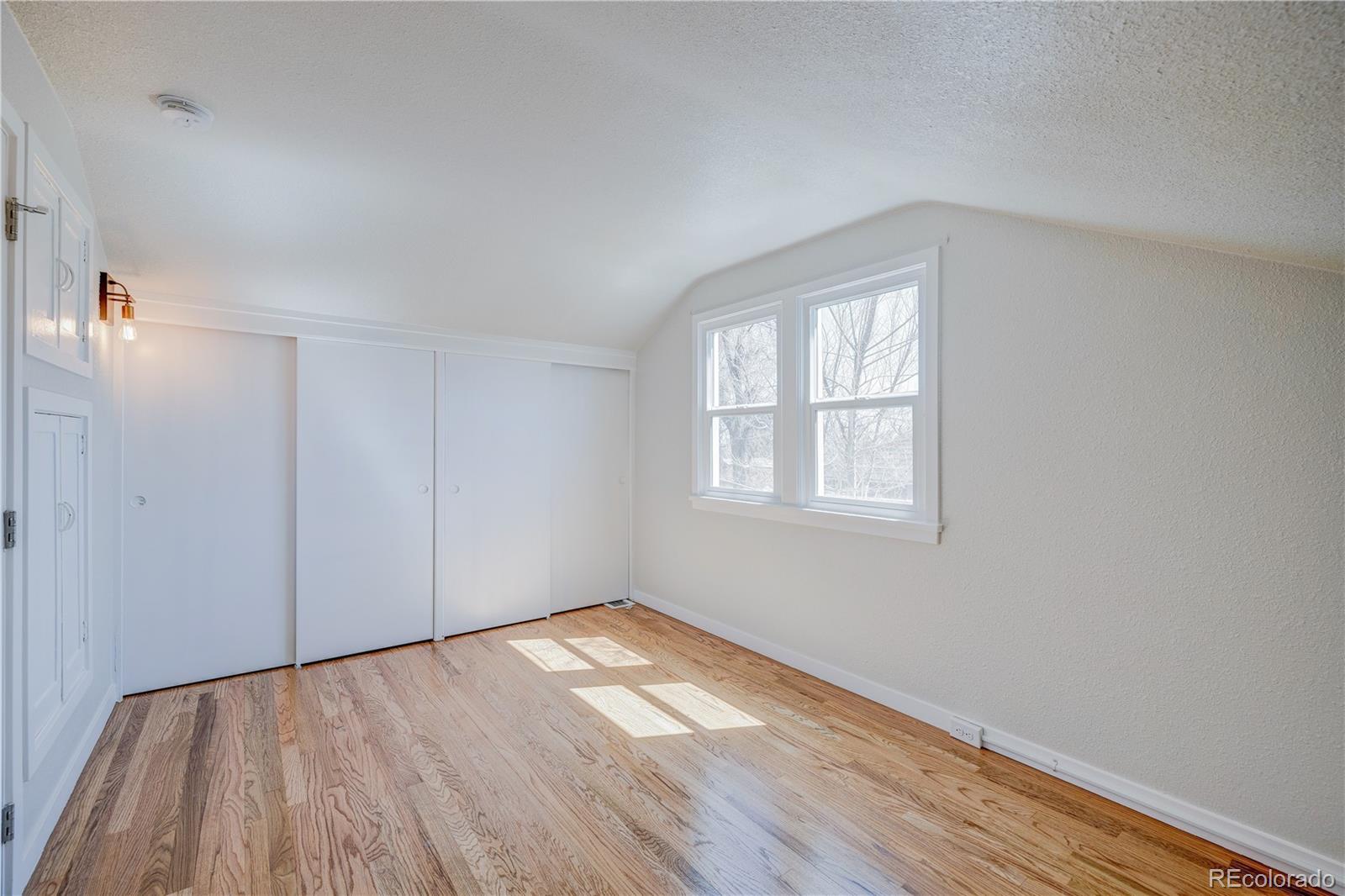 2932 Chase Street Wheat Ridge, CO 80214 - Photo 16 of 30 an empty room with wooden floor and windows