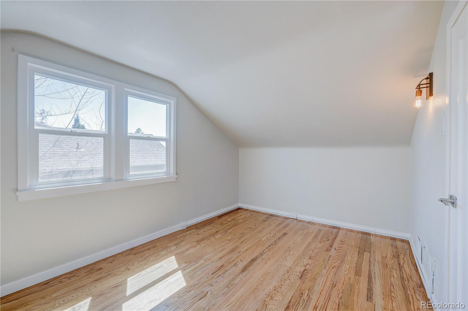 2932 Chase Street Wheat Ridge, CO 80214 - Photo 17 of 30 an empty room with wooden floor and windows
