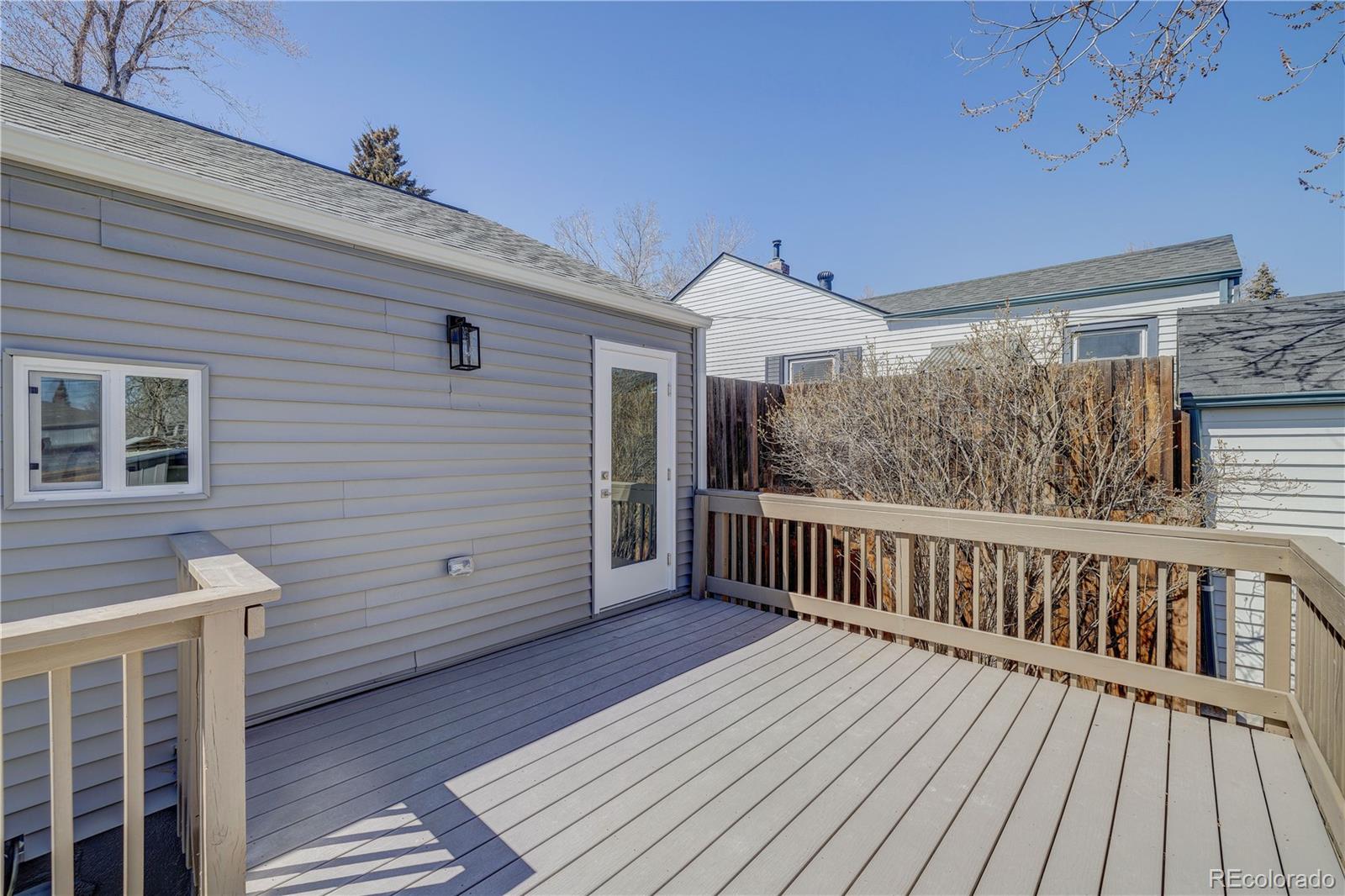 2932 Chase Street Wheat Ridge, CO 80214 - Photo 25 of 30 a view of backyard with wooden deck and floor to ceiling window