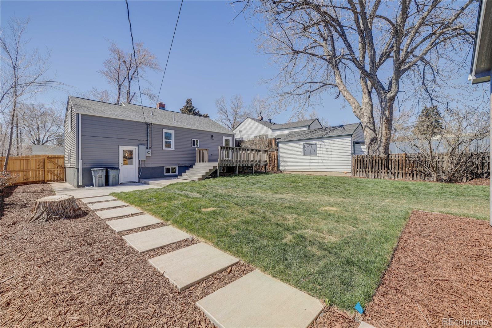 2932 Chase Street Wheat Ridge, CO 80214 - Photo 28 of 30 a front view of a house with a yard and garage