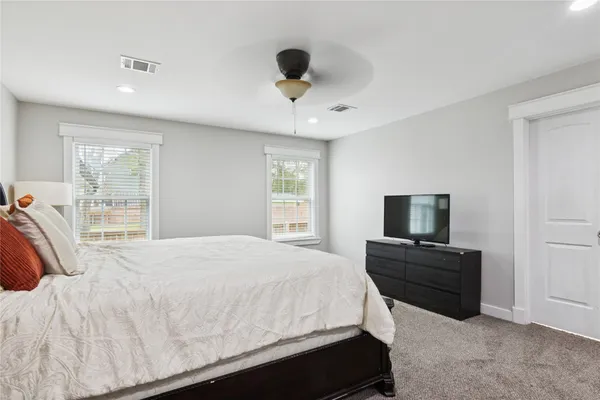 a large bedroom with a bed and a large window