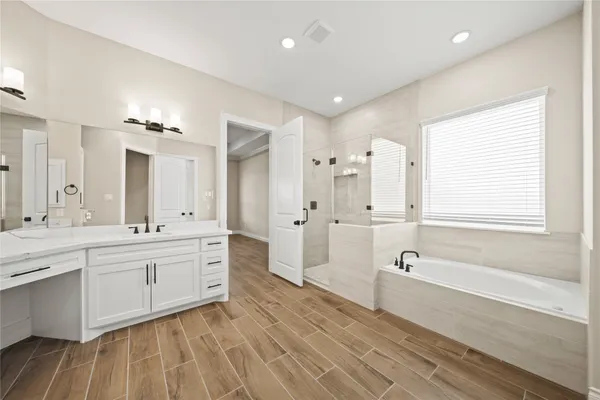 a spacious bathroom with a double vanity sink a mirror and a bathtub
