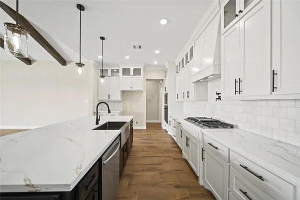 a kitchen with stainless steel appliances granite countertop a sink a stove and a refrigerator