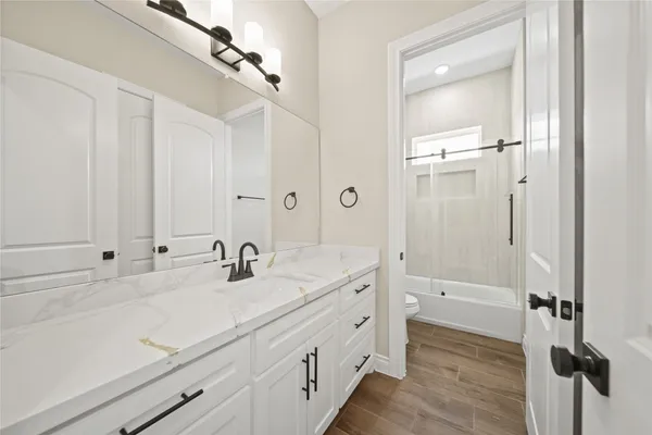 a bathroom with a double vanity sink a mirror and a shower