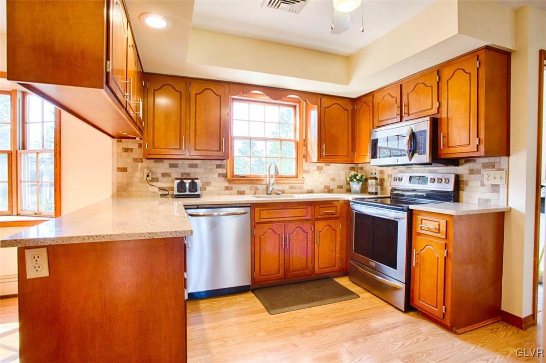 187 Nolf Road Nazareth, PA 18064 - Photo 3 of 33 a kitchen with stainless steel appliances granite countertop a stove a sink dishwasher a refrigerator and a microwave oven with wooden floor