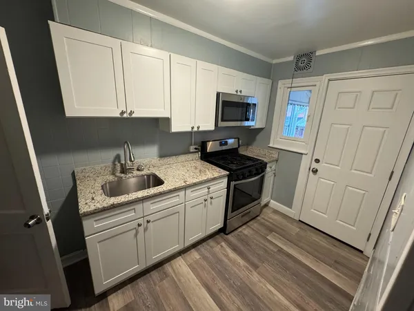 a kitchen with a sink appliances and cabinets