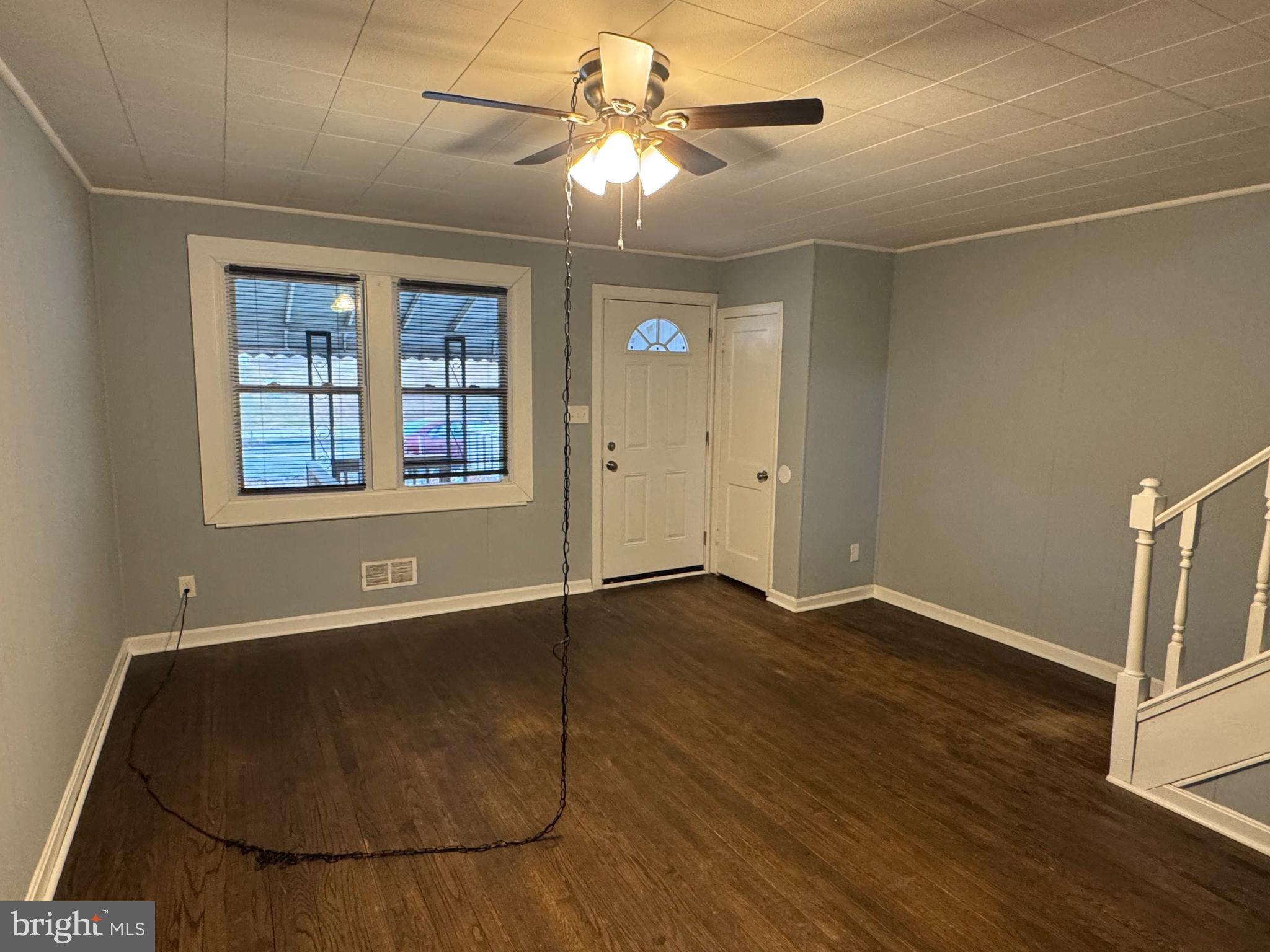 418 Stemmers Run Road Essex, MD 21221 - Photo 3 of 23 a view of an empty room with window and wooden floor