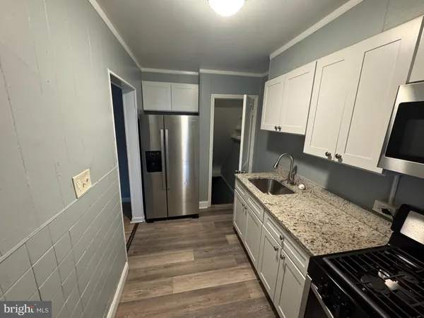 a kitchen with stainless steel appliances granite countertop a refrigerator and a sink