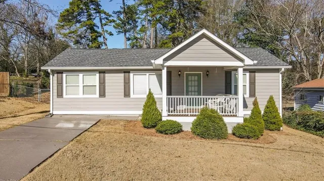 a front view of a house with a yard and potted plants