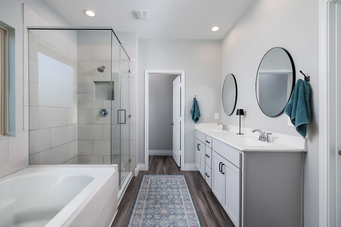 1507 Oakdale Crest Road Montgomery, TX 77316 - Photo 17 of 23 a bathroom with a double vanity sink a large mirror a bathtub and shower