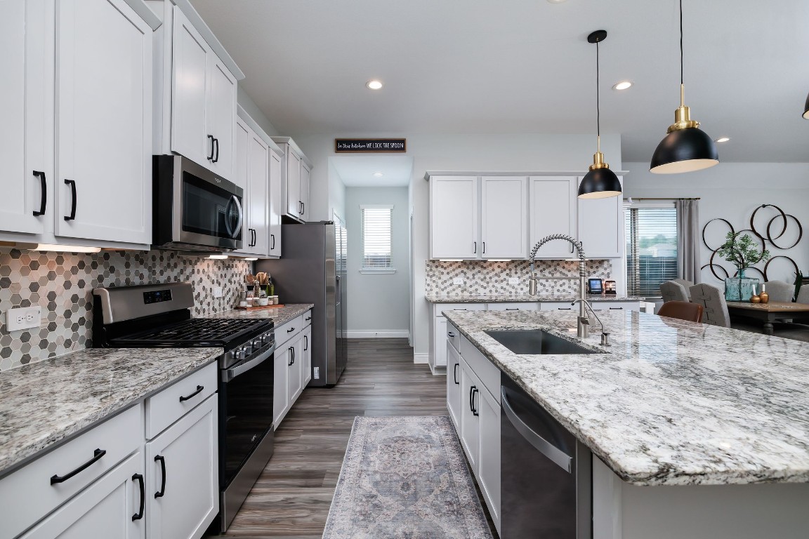 1507 Oakdale Crest Road Montgomery, TX 77316 - Photo 3 of 23 a kitchen with stainless steel appliances granite countertop a sink a stove and a wooden cabinets