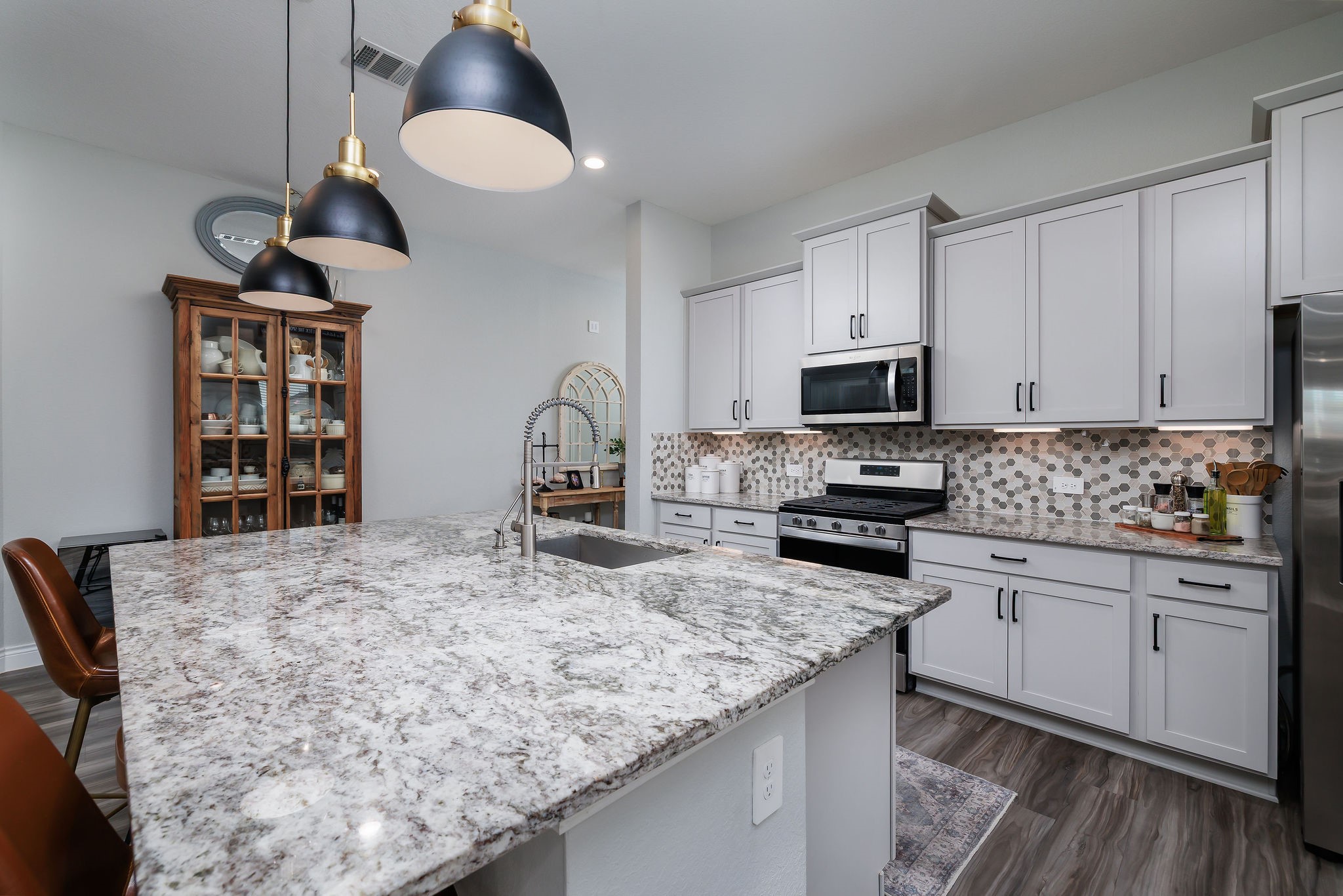 1507 Oakdale Crest Road Montgomery, TX 77316 - Photo 4 of 23 a kitchen with stainless steel appliances granite countertop a stove top oven a sink a dining table and chairs with wooden floor